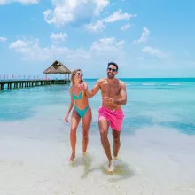 Pareja caminando en la playa club de playa todo incluido Cozumel